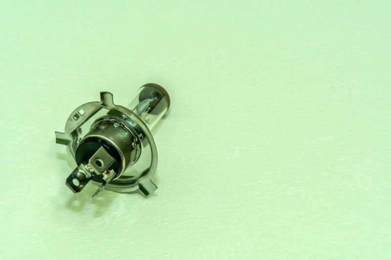 Automobile halogen headlamp bulb isolated on textured background