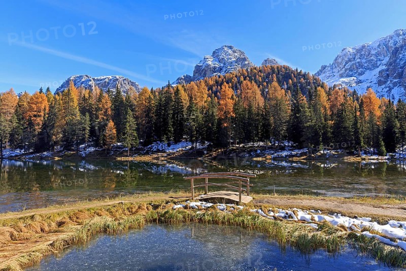 Autumn mountain landscape with a bridge over a clear lake and snow-covered peaks, Italy, South Tyrol, Belluno, Dolomites, Lago d'Antorno against Cadini, Misurina, Sesto Dolomites, Veneto, Europe