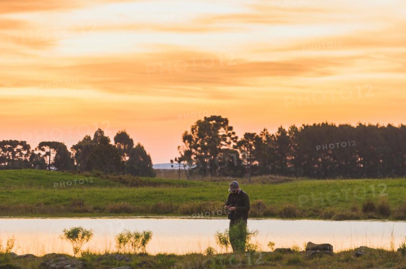 Sport fisherman fishing in lake on cloudy day, Cambara do sul, Rio Grande do sul, Brazil, South America
