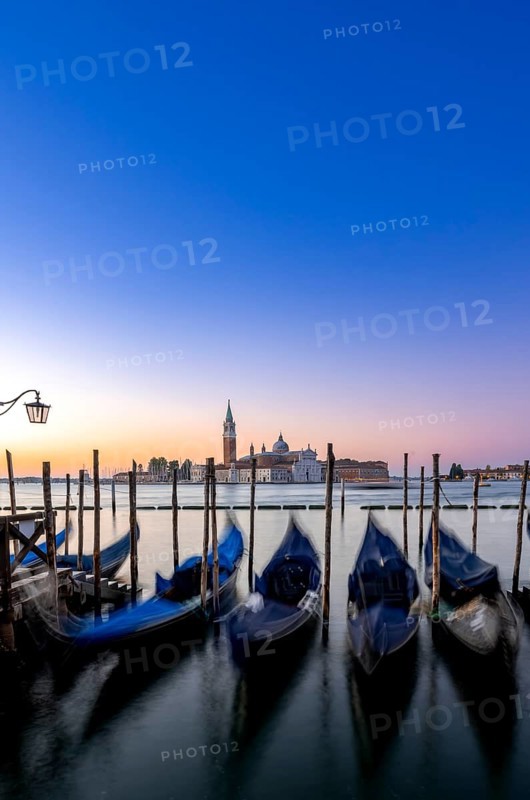 Venetian gondolas, boat dock at St Mark's Square, church of San Giorgio Maggiore in the background, long exposure at sunrise, Venice, Veneto, Italy, Europe