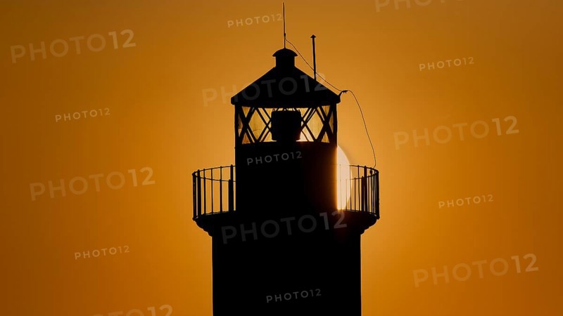 A lighthouse in silhouette with a dazzling sunrise in the background, sunrise, dawn, Fort of Saint Nikolaos, harbour promenade, Rhodes, Dodecanese, Greek Islands, Greece, Europe