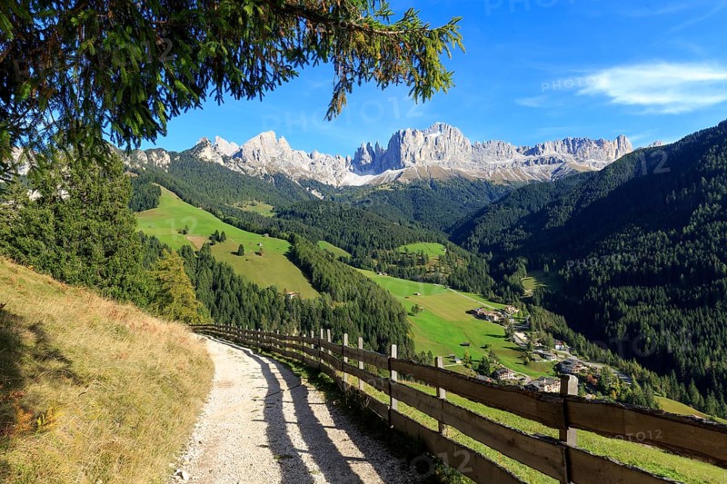 Sunlit hiking trail with a view of the mountain landscape and bright blue sky, Italy, Alto Adige, Bolzano province, Dolomites, Catinaccio/rose garden, Europe