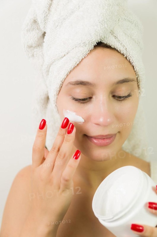 Hydration. Cream smear. Beuaty close up portrait of young woman with a healthy glowing skin is applying a skincare product