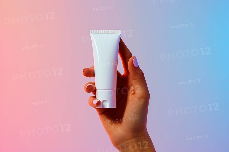 Woman's hand holding white cream tube in front of studio background. Close up of wind mill turbine covered in ic ein winter, AI generated