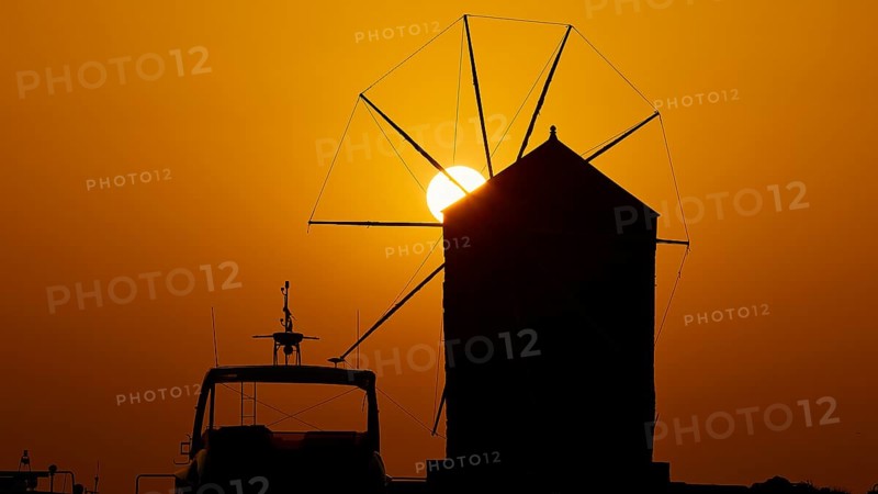 Silhouette of a windmill against the background of an orange sunrise sky, twilight, Mandraki Oat, Rhodes, Dodecanese, Greek Islands, Greece, Europe