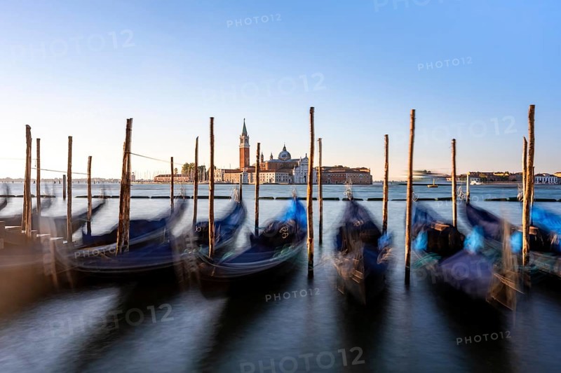 Venetian gondolas, boat dock at St Mark's Square, church of San Giorgio Maggiore in the background, long exposure in the morning light, Venice, Veneto, Italy, Europe