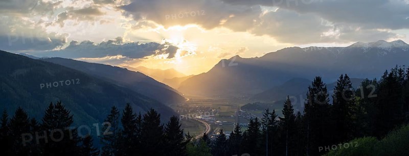 Cloudy mood in the evening light, sunset over the Liesingtal, in the evening light the village Traboch, Schoberpass federal road, view from the lowlands, panoramic shot, Leoben, Styria, Austria, Europe