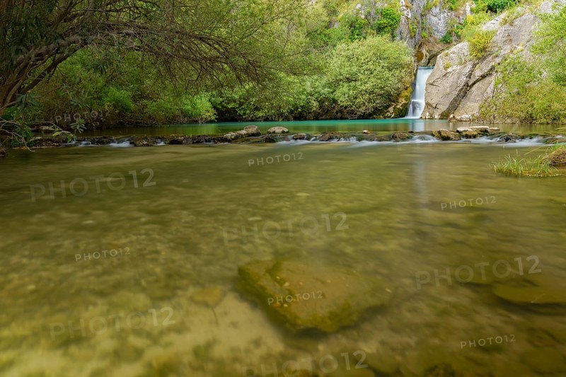 Waterfall of a mountain river with lush vegetation silk effect long exposure photography