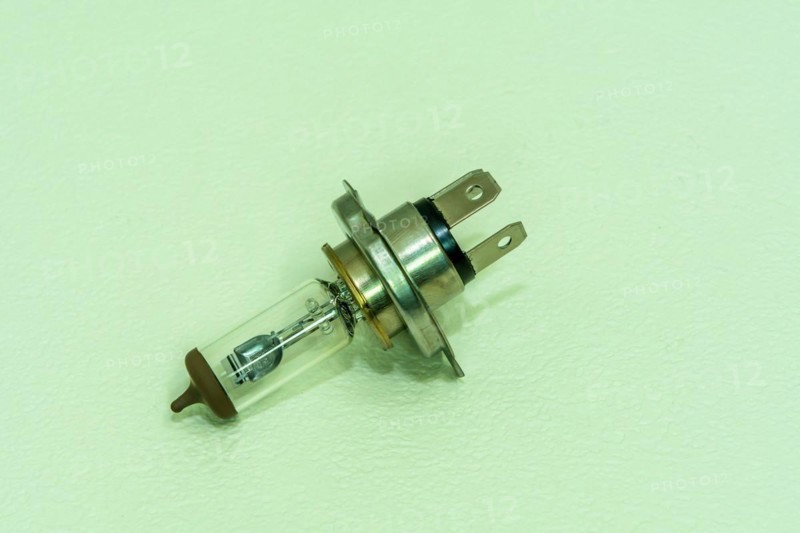 Automobile halogen headlamp bulb isolated on textured background