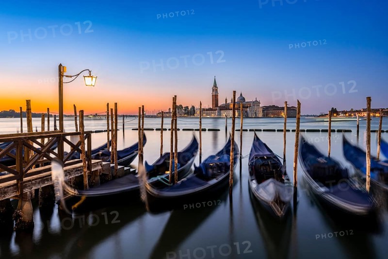 Venetian gondolas, boat dock at St Mark's Square, church of San Giorgio Maggiore in the background, long exposure at sunrise, Venice, Veneto, Italy, Europe