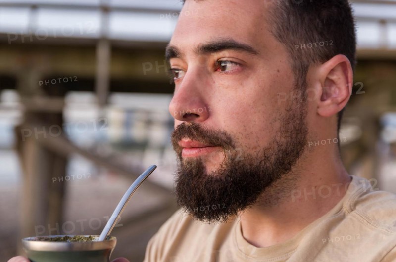 Man drinking chimarrao, mate tea tea (an infusion of yerba mate tea tea with hot water) at sunset in uruguay