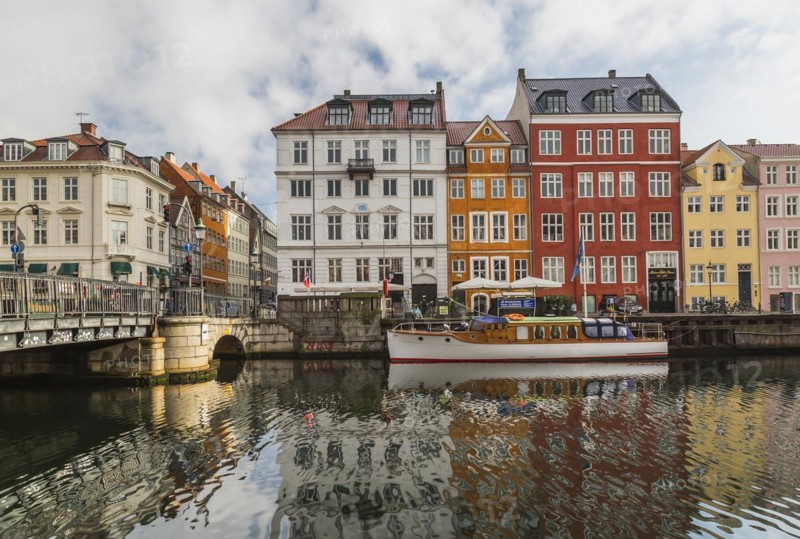 Canal bridge with moored boat and colourful 17th century apartment buildings and houses along the Nyhavn canal, Copenhagen, Denmark, Europe