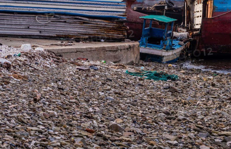 Old rusty abandoned ships sitting on the shore amid trash and debris at a marine junkyard in South Korea
