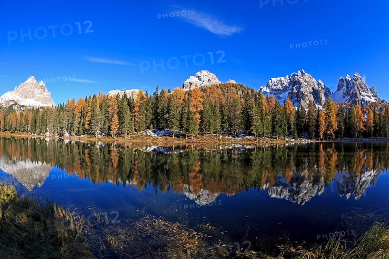 A panoramic picture of a mountain lake, surrounded by forests in autumn dress with a clear reflection of the mountains, Italy, South Tyrol, Belluno, Dolomites, Lago d'Antorno against Cadini, Misurina, Sesto Dolomites, Veneto, Europe