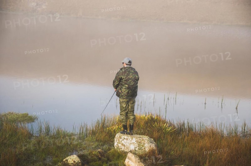 Sport fisherman fishing in lake on cloudy day, Cambara do sul, Rio Grande do sul, Brazil, South America