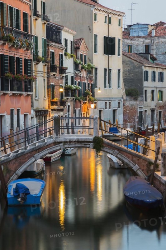 Moored boats and footbridge over Rio de la Toletta Canal with old architectural style residential buildings at dusk, Dorsoduro district, Venice, Veneto, Italy, Europe
