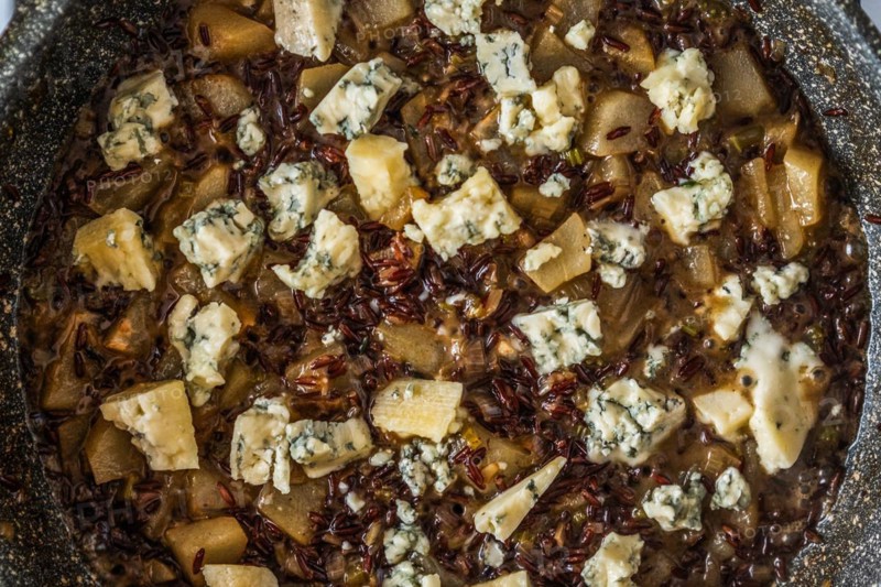 Closeup top view of frying pan with risotto with pear and blue cheese