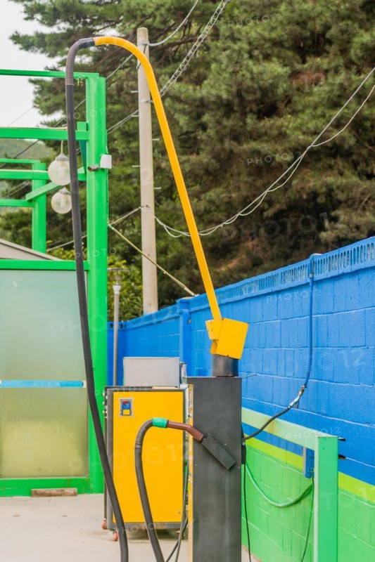 Side view of vacuum cleaner with hose attached with green duct tape at gas station car wash in South Korea
