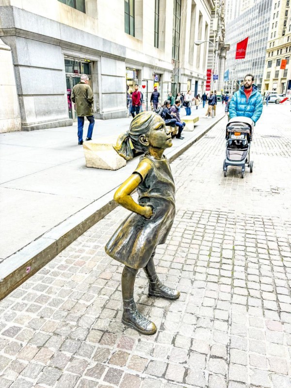 Bronze sculpture Fearless Girl by Kristen Visbal on Broad Street opposite the New York Stock Exchange, New York City