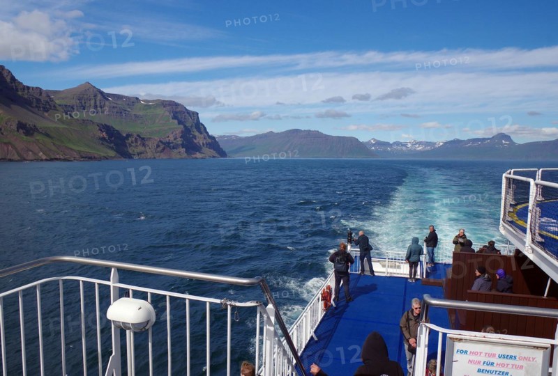 People queuing at the railing of the car ferry Noerroena at the entrance to a fjord, ferry between Denmark and Iceland, Seydifjoerdur, Iceland, Europe