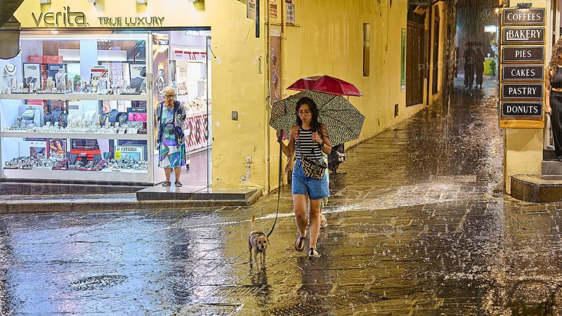 A woman walking her dog along a rainy street, night shot, Rhodes Old Town, Rhodes, Dodecanese, Greek Islands, Greece, Europe