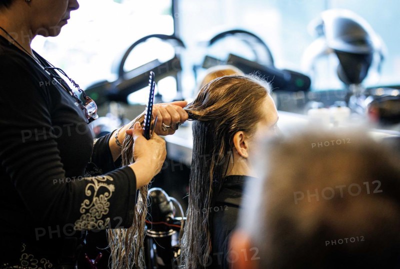 Valentyna Vysotska, hairdresser from Ukraine, combs her customer's hair, taken at the hairdressing salon Coiffeur Sivan in Berlin, 22/04/2024