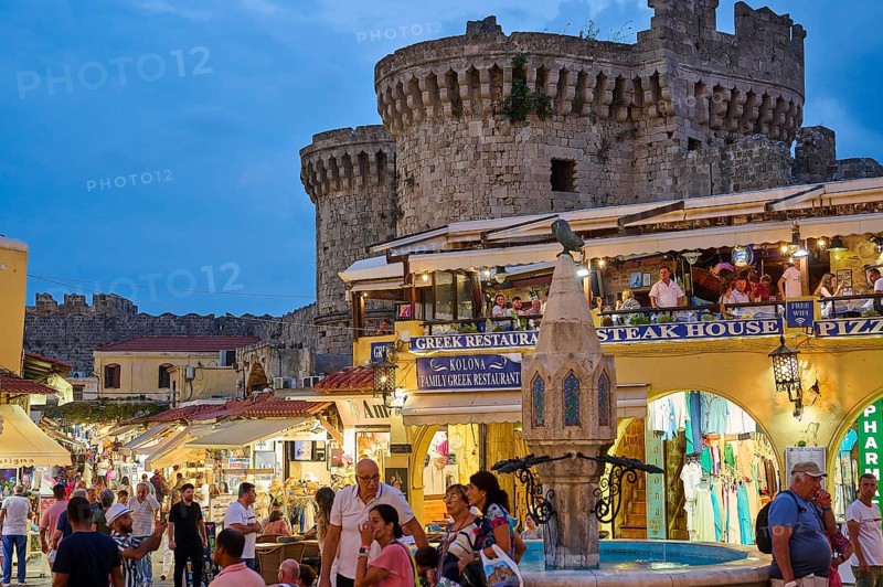 Hippocrates Square, St Paul's Gate, visitors walk between restaurants and shops by an old castle, night shot, Rhodes Old Town, Rhodes, Dodecanese, Greek Islands, Greece, Europe