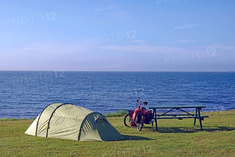 Tent and bike in a meadow with a view of the open sea, Cycling holidays, Outdoor, Husavik, Iceland, Europe