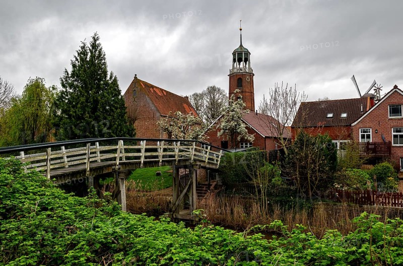 Luettje Bruegg across the Ditzum-Bunder Sieltief in the fishing village of Ditzum, behind the bell tower of the Protestant Reformed Church, municipality of Jemgum, district of Leer, Rheiderland, East Frisia, Lower Saxony, Germany, Europe