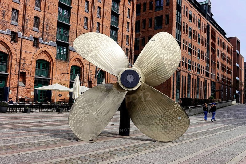 International Maritime Museum, Koreastrasse, Hafencity, Hamburg, A large ship's propeller in front of historic brick buildings on an urban promenade, Hamburg, Hanseatic City of Hamburg, Germany, Europe