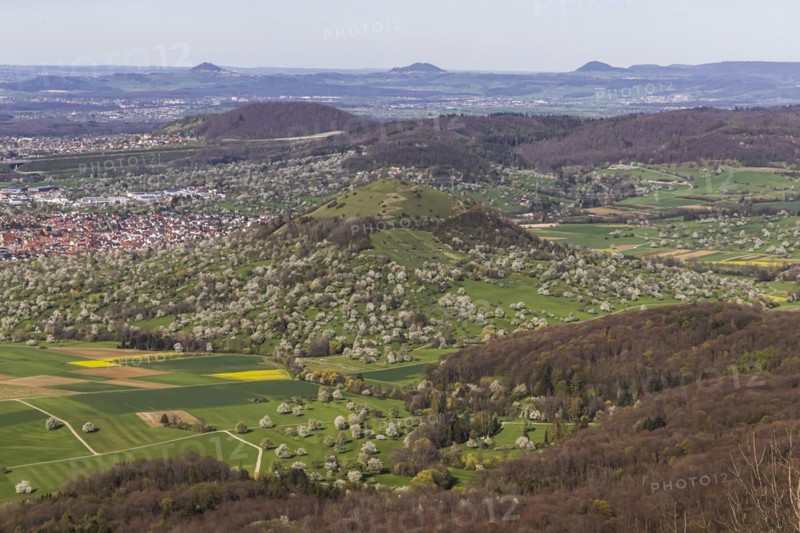 Breitenstein near Ochsenwang, rocky outcrop of the Swabian Alb, 811 metre high rocky plateau, view of the Alb foreland with blossoming fruit trees on orchards in spring, Three Imperial Mountains Hohenstaufen, Rechberg and Stuifen, Bissingen an der Teck, Baden-Wuerttemberg, Germany, Europe