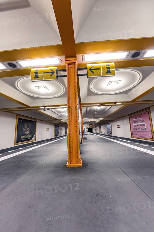 Underground station with artistic yellow columns and advertising posters on the walls, Berlin, Germany, Europe