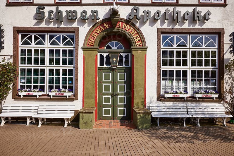 Entrance door of the Swan pharmacy with windows, flower boxes and benches in the city centre of Husum, Nordfriesland district, Schleswig-Holstein, Germany, Europe