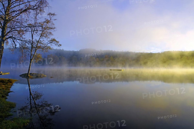 Sunrise and autumnal morning mist over a calm lake, foliage colouring, Bullaren, Bohuslaen. Sweden