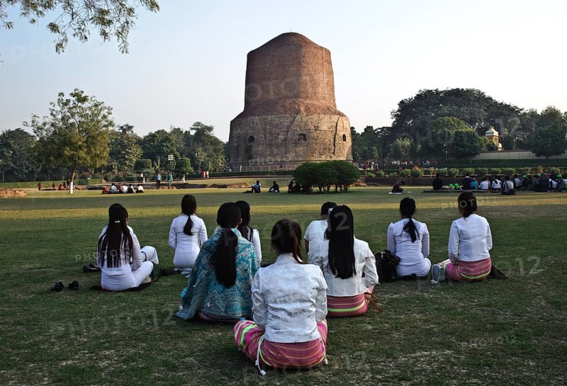 Buddhist young women from South east Asia, meditation in a buddhist pilgrimage site, Sarnath stupa, India, Asia