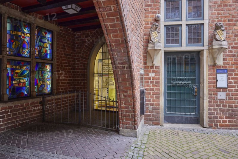 House entrance with old door, windows and two lions bearing a coat of arms with the key of Bremen and illuminated colourful windows in Boettcherstrasse, Bremen, Hanseatic City, State of Bremen, Germany, Europe