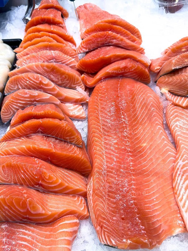 Display of Pacific salmon (Oncorhynchus) caught by fishing in the form of salmon fillet on ice in refrigerated counter Fish counter of fishmonger Fish retail, food trade, wholesale, fish trade, speciality shop, Germany, Europe