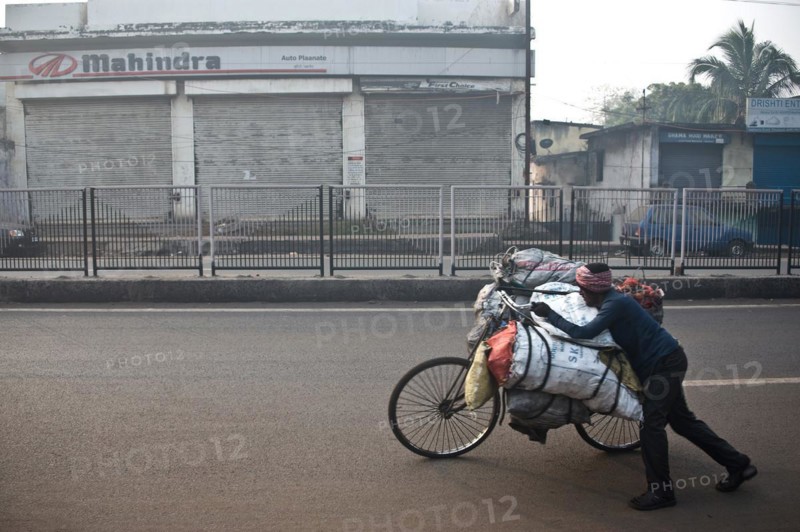 Man, carrying on bike, street, coal, selling to urban dwellers, restaurants, shops, Dhanbad, Bihar, India, Asia