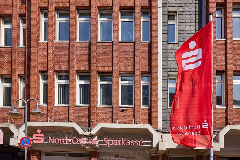 Nord-Ostsee Sparkasse with facade and flag in Husum, district of Nordfriesland, Schleswig-Holstein, Germany, Europe