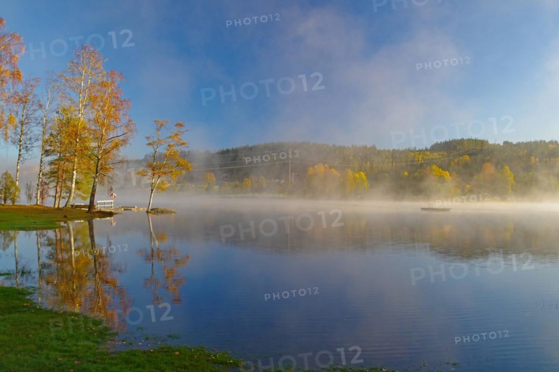 Sunrise and autumnal morning mist over a calm lake, foliage colouring, Bullaren, Bohuslaen. Sweden