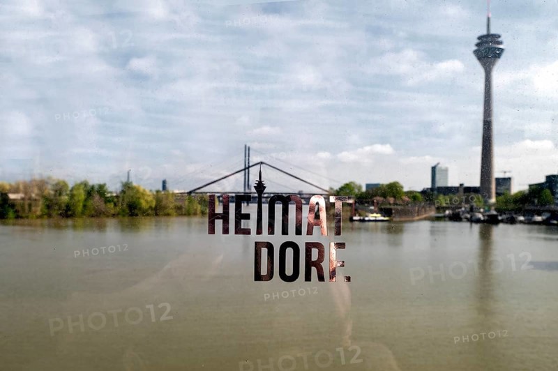 View through transparent balustrade on the Living Bridge harbour bridge in the Media Harbour to the Rheinknie Bridge and Rhine Tower, inscription Heimatdorf, Duesseldorf, North Rhine-Westphalia, Germany, Europe