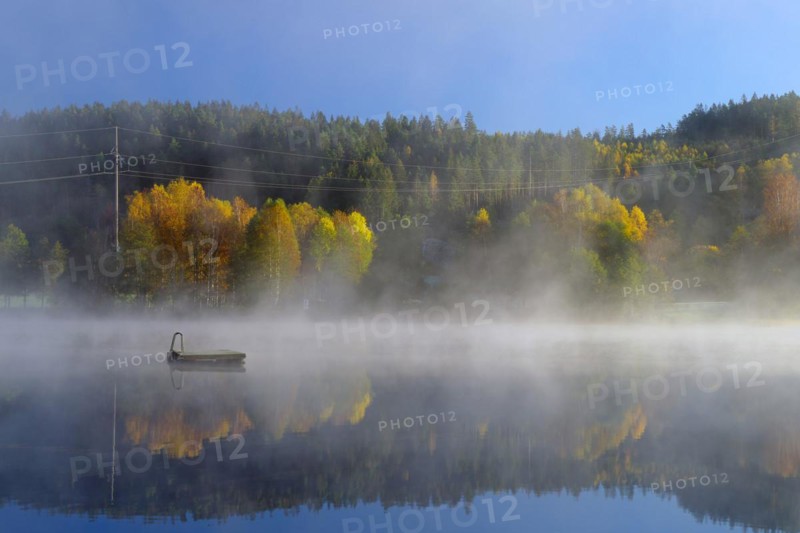 Autumn morning mist over a calm lake, foliage colouring, Bullaren, Bohuslaen. Sweden