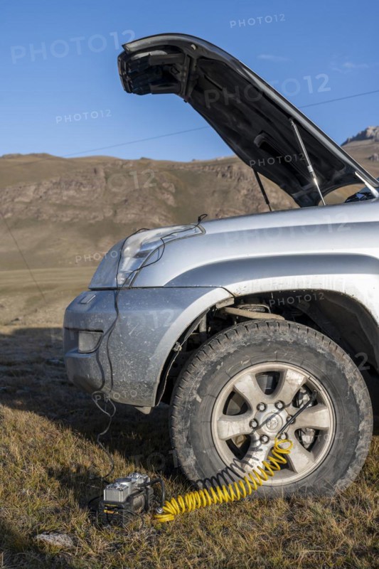 Compressor, inflating a car tyre, off-road vehicle, Kyrgyzstan, Asia