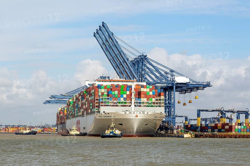 OOCL Zeebrugge container ship at quayside Port of Felixstowe, Suffolk, England, UK tugs arriving to assist departure
