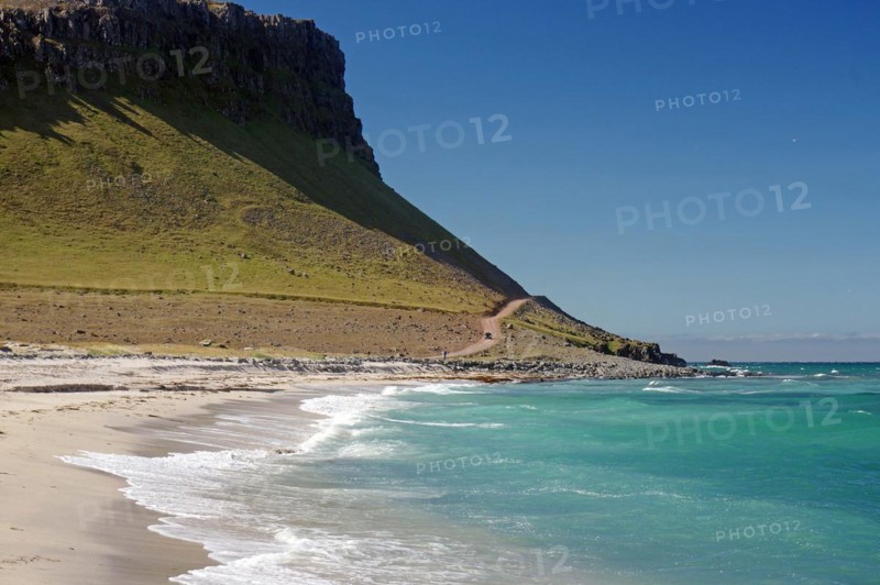 Lonely sandy beach and gravel track in front of vegetation-free mountains, Latrabjarg, Westfjords, Iceland, Europe