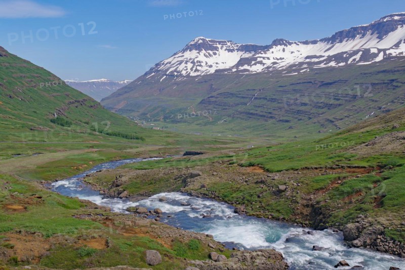 Water falls into a deeply incised valley framed by high mountains, ferry town, Seydisfjoerdur, East Iceland, Iceland, Europe
