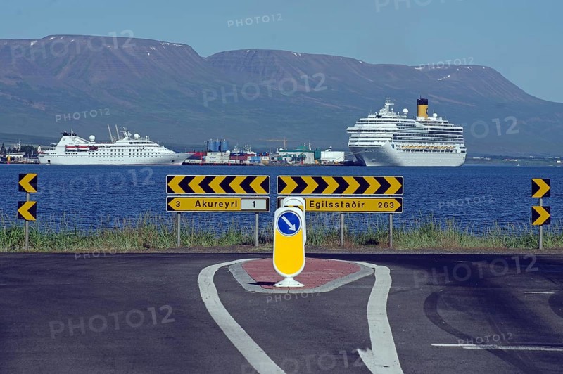 Street with distances, behind it the sea with two cruise ships, Akureyri, Iceland, Europe