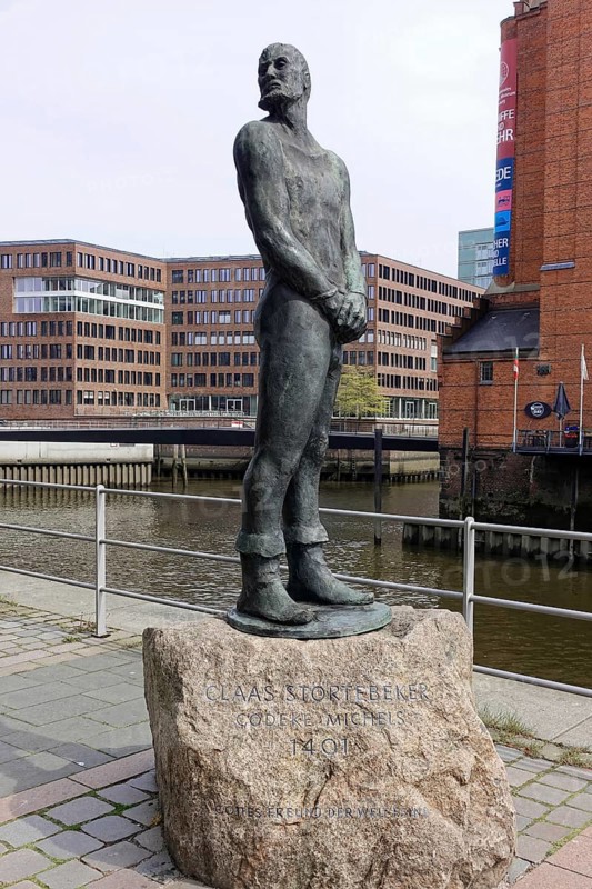Stoertebecker sculpture on Stoertebecker Ufer, Elbtorpromenade, Hafencity, Hamburg, bronze statue of Claus Stoertebeker with a view of the river and surrounding buildings, Hamburg, Hanseatic City of Hamburg, Germany, Europe