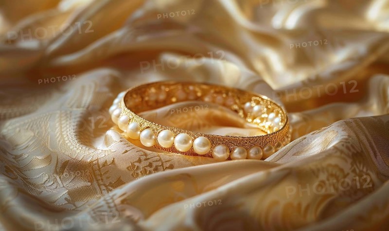 A pearl bangle bracelet with intricate detailing laid out on a smooth satin material background AI generated