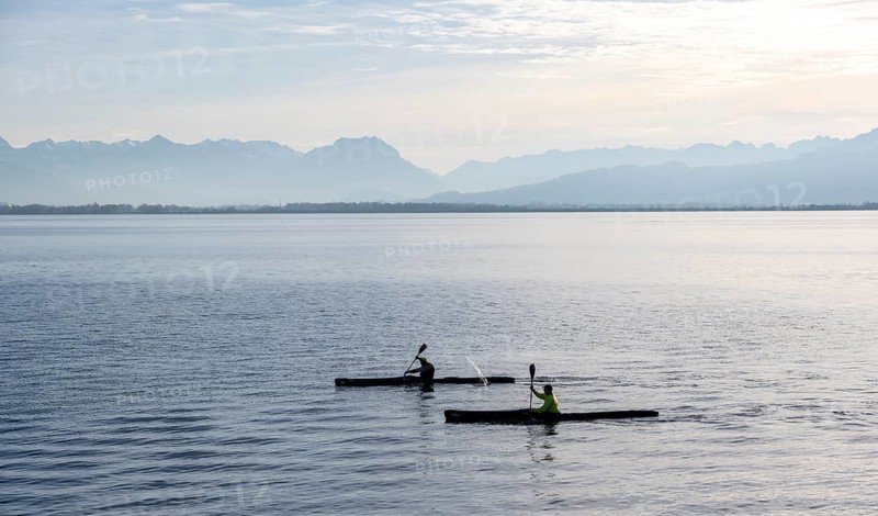 Kayakers paddling in Lake Constance in the evening light, snow-covered mountain peaks, Lindau Island, Lake Constance, Bavaria, Germany, Europe